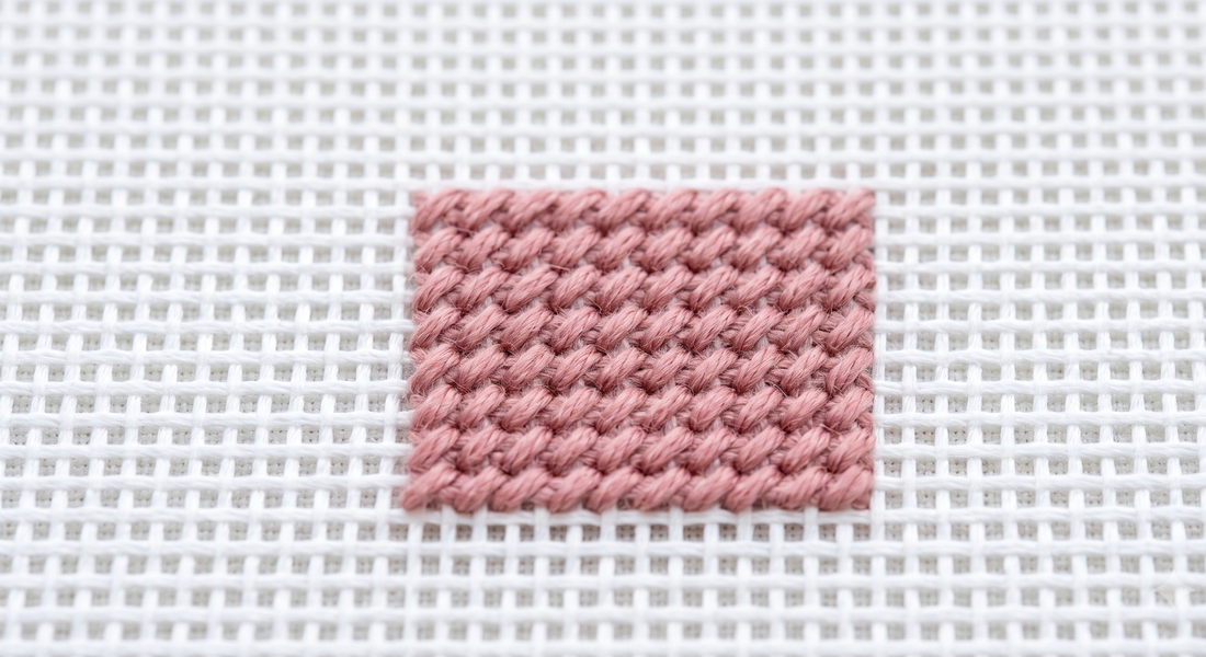 Evenly tensioned tent stitches lying flat on needlepoint canvas — correct relaxed tension