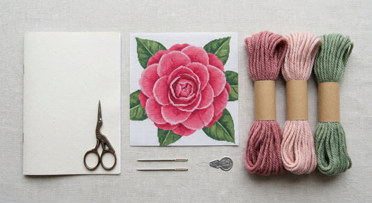 Complete beginner needlepoint kit contents laid out in a grid